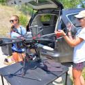 CREWS undergraduate students Maddie Torrey, left, and Shannon Hamp, right, begin the process of packing up the drone after a flight on the Upper Clark Fork River in July 2021.  