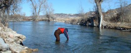 A volunteer takes a water sample on the Crow Reservation. MSU photo.