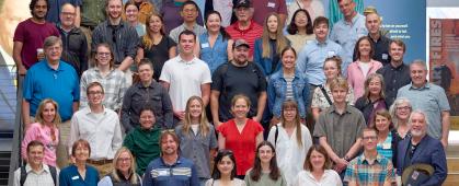 attendees pose together for a group photo on a set of stairs